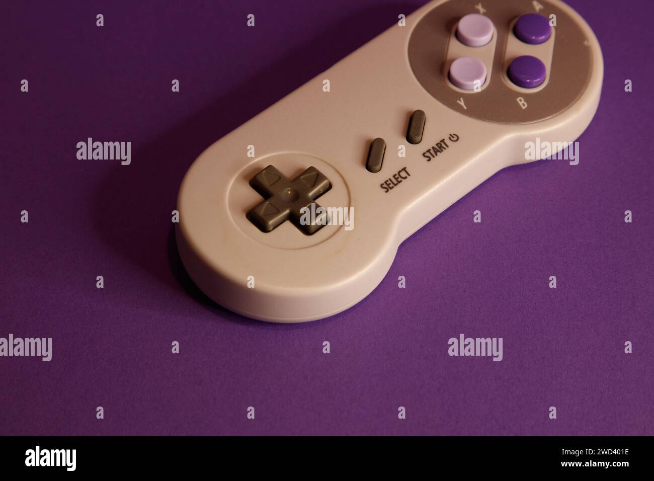 Console per videogiochi di tipo Nintendo su sfondo mouve, fotografia in studio Foto Stock