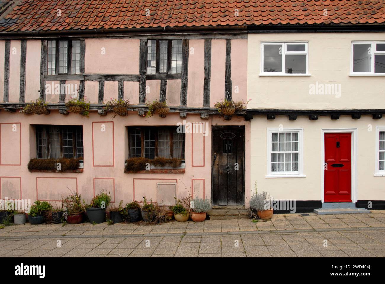 Parte di antiche case a schiera, una con porta rossa brillante, Beccles, Suffolk, Inghilterra Foto Stock