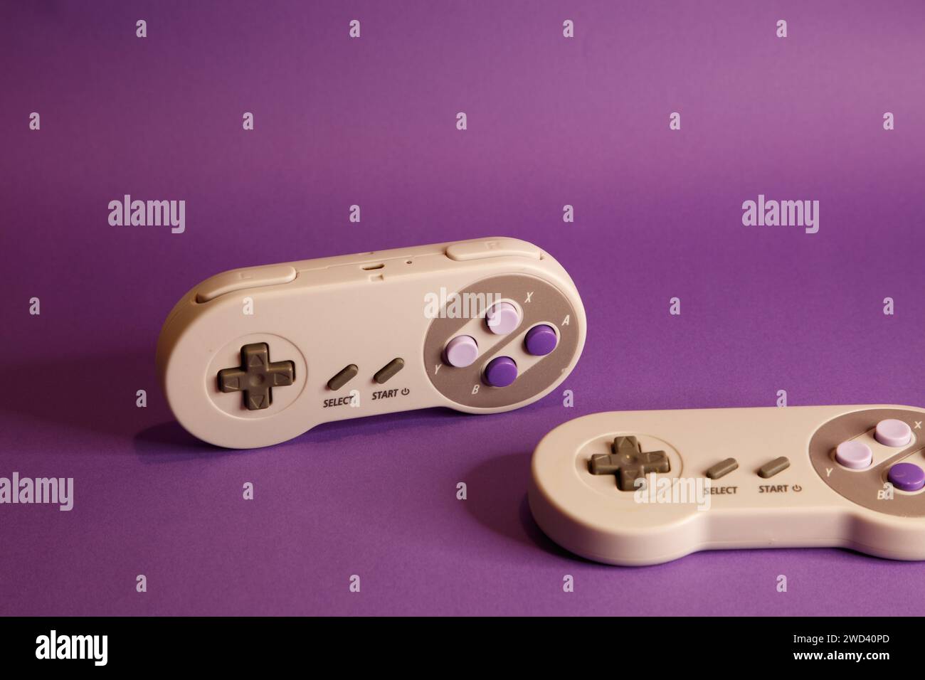 Console per videogiochi di tipo Nintendo su sfondo mouve, fotografia in studio Foto Stock