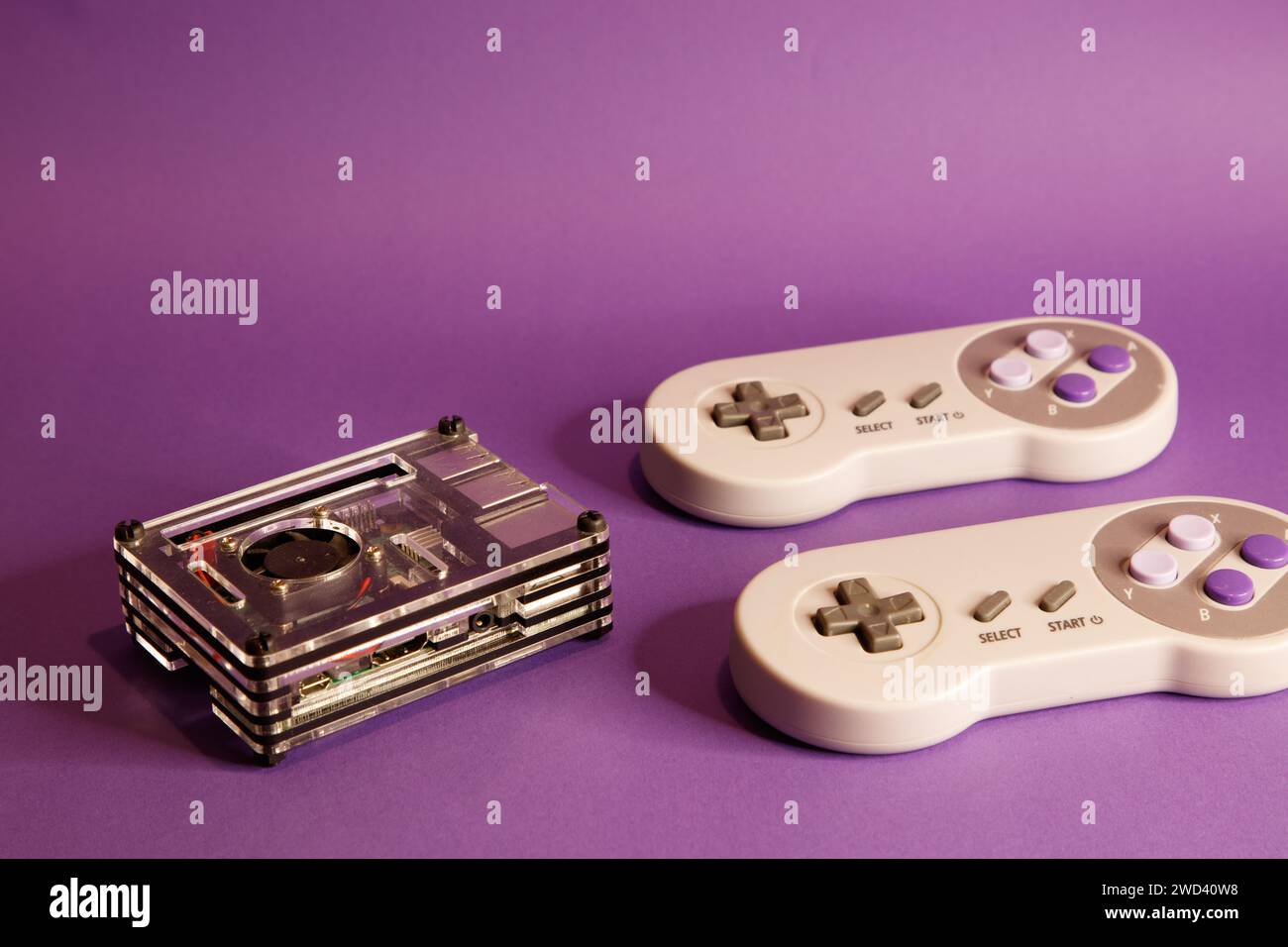 Console per videogiochi di tipo Nintendo e un computer Raspberry Pie, su sfondo con mouse, fotografia in studio Foto Stock