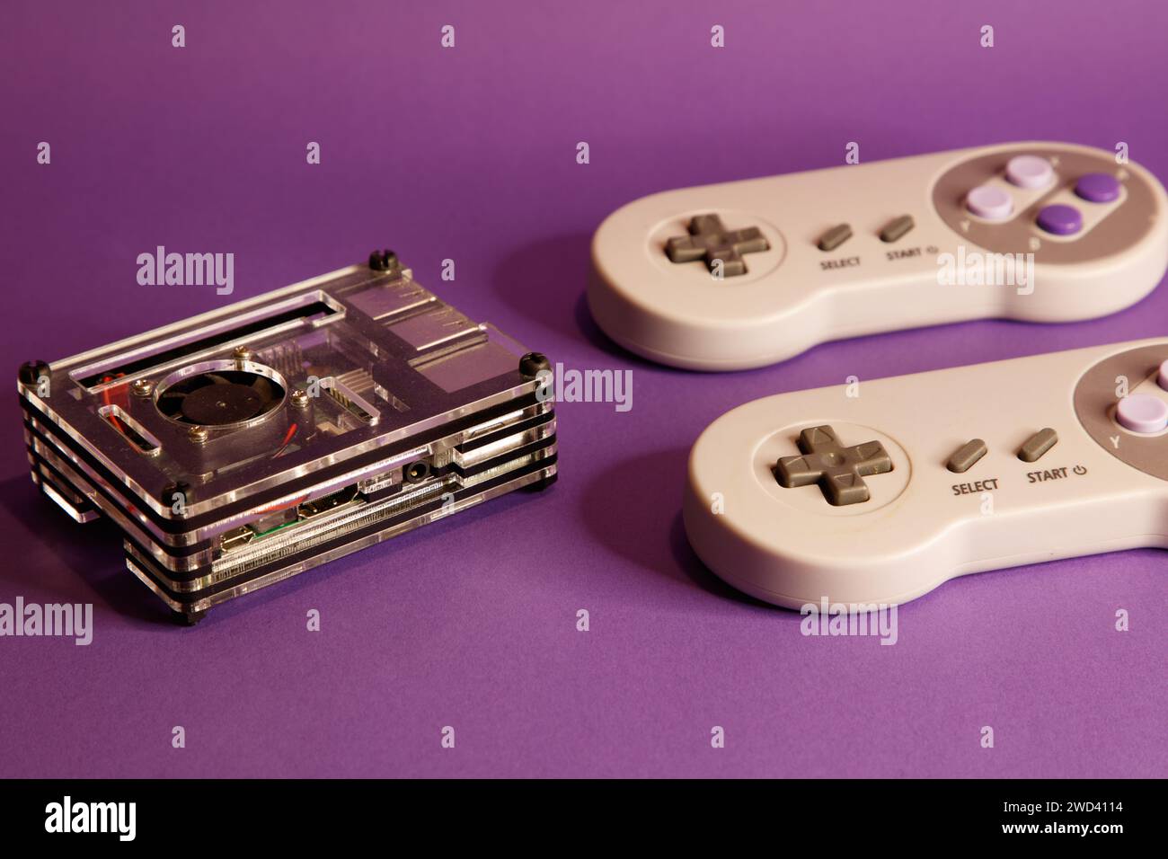 Console per videogiochi di tipo Nintendo e un computer Raspberry Pie, su sfondo con mouse, fotografia in studio Foto Stock