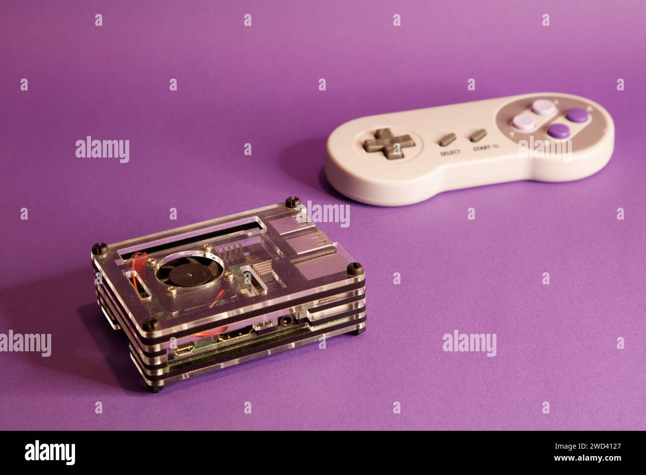 Console per videogiochi di tipo Nintendo e un computer Raspberry Pie, su sfondo con mouse, fotografia in studio Foto Stock