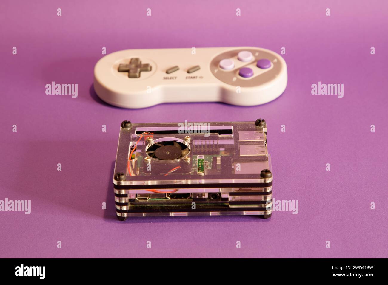 Console per videogiochi di tipo Nintendo e un computer Raspberry Pie, su sfondo con mouse, fotografia in studio Foto Stock