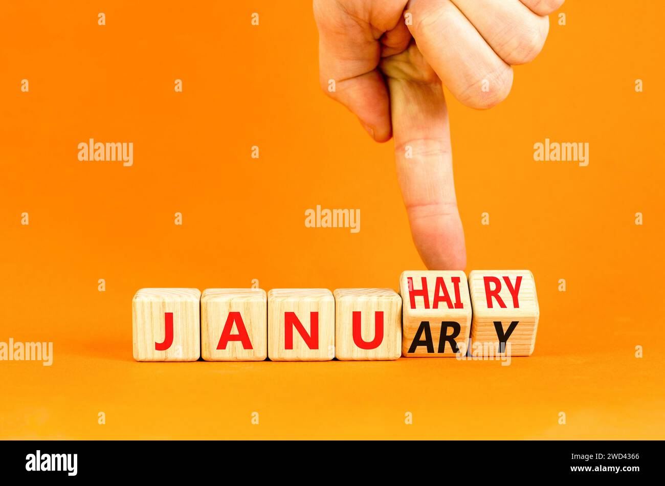 Januhairy o simbolo di gennaio. Parole di concetto Januhairy o January su bellissimi blocchi di legno. Bellissimo sfondo arancione. Mano d'uomo. Sociale Foto Stock