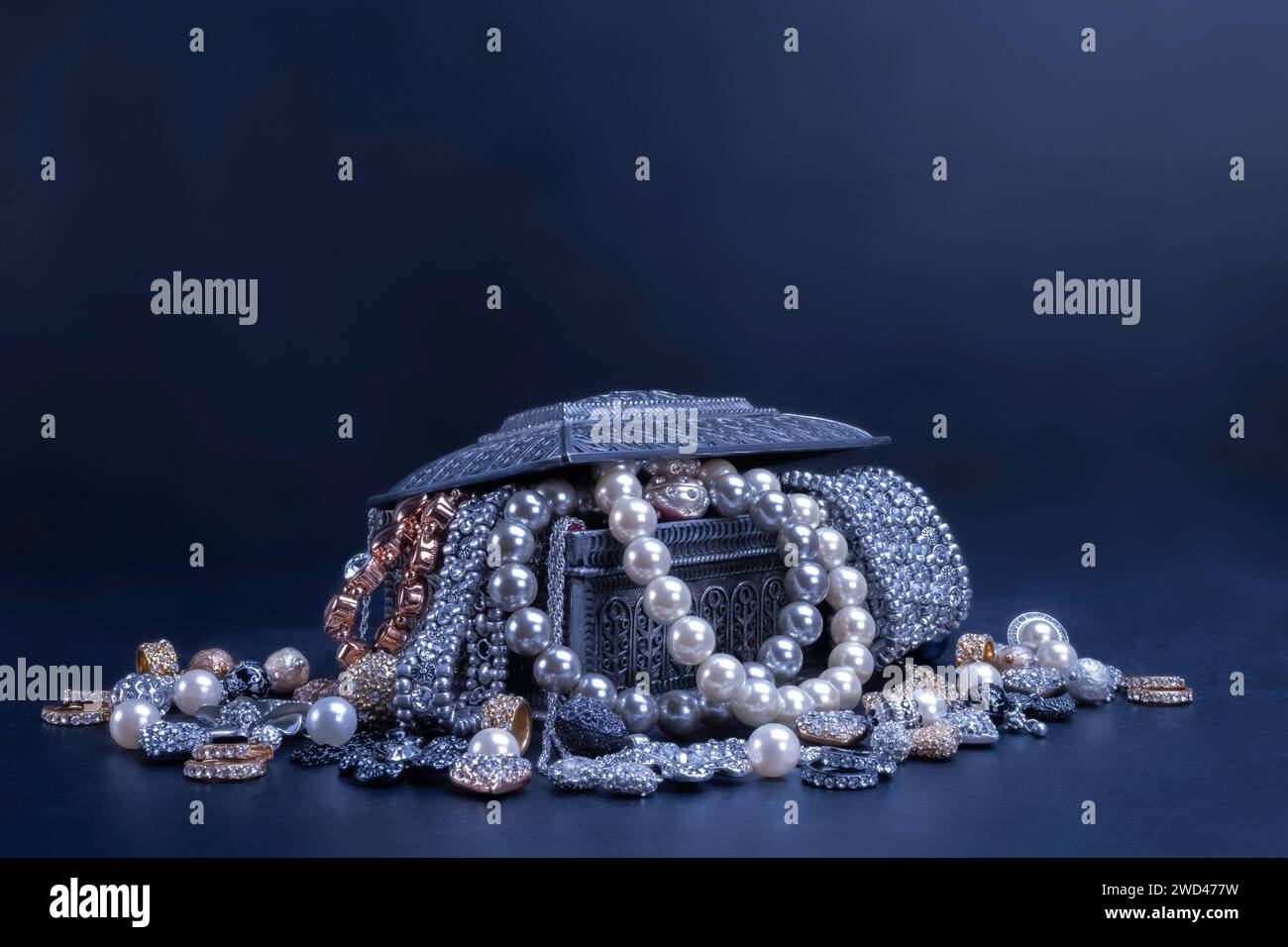 Vari gioielli perle oro e argento in una scatola argentata su sfondo nero. Bracciali, orecchini, collane, moda, accessori, concetto di gioielleria. Foto Stock