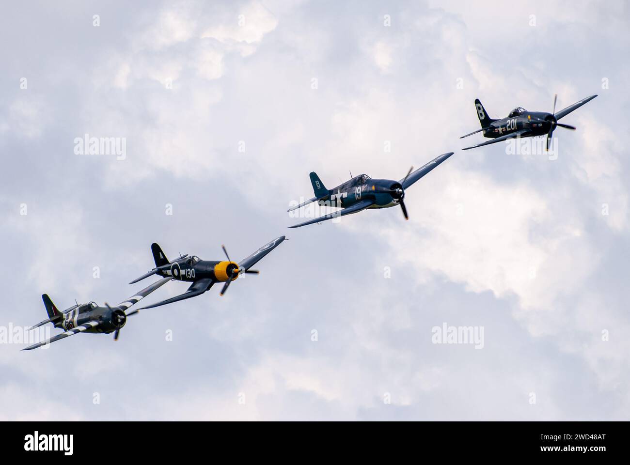 Gli aerei da caccia americani della seconda guerra mondiale volano in stretta formazione nel cielo. F4U corsair, F8F Wildcat, F4F tra gli altri. Foto Stock