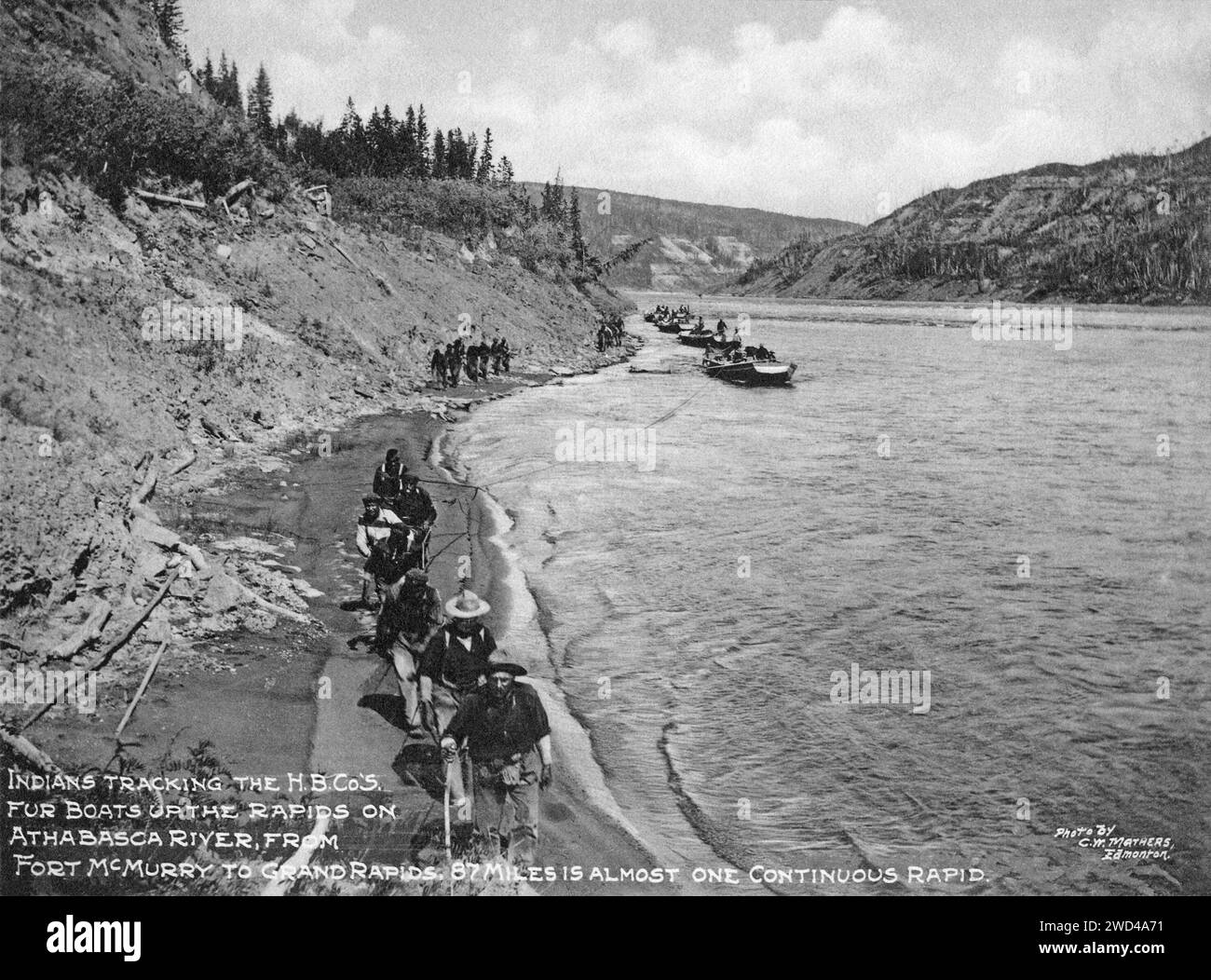 Una fotografia del 1901 delle imbarcazioni in pelliccia della compagnia della Baia di Hudson trainate a monte sul fiume Athabasca, Alberta, scattata da C W Mathers in una spedizione nell'estremo nord del Canada e pubblicata nel suo libro "l'estremo nord". Mathers ha descritto questa foto: Gli indiani [persone delle prime Nazioni] che seguono il H.B.c' so. Le barche a pelliccia lungo le rapide del fiume Athabasca, da Fort McMurray a Grand Rapids, 87 miglia sono quasi una rapida continua. Foto Stock