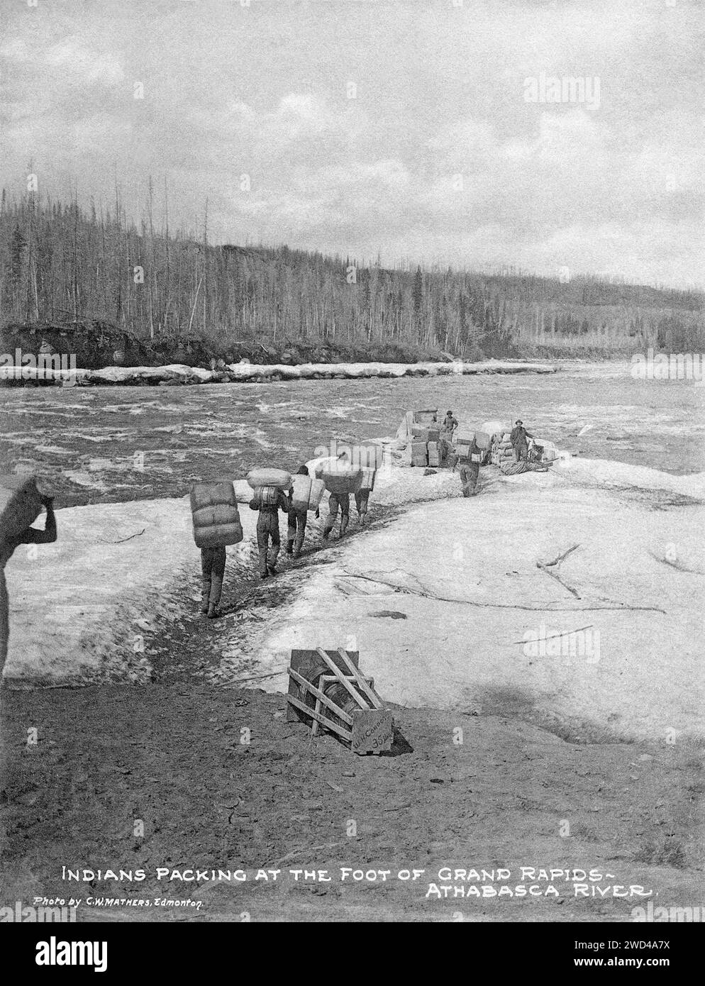 Una fotografia del 1901 di un autoctono «Packers» delle prime Nazioni che trasportava carichi pesanti sulle spalle del fiume Athabasca, Alberta, scattata da C W Mathers in una spedizione nell'estremo nord del Canada e pubblicata nel suo libro «l'estremo nord». Mathers ha didascalato questa foto: Gli indiani [persone delle prime Nazioni] stanno facendo il carico ai piedi delle Grand Rapids – fiume Athabasca. Foto Stock