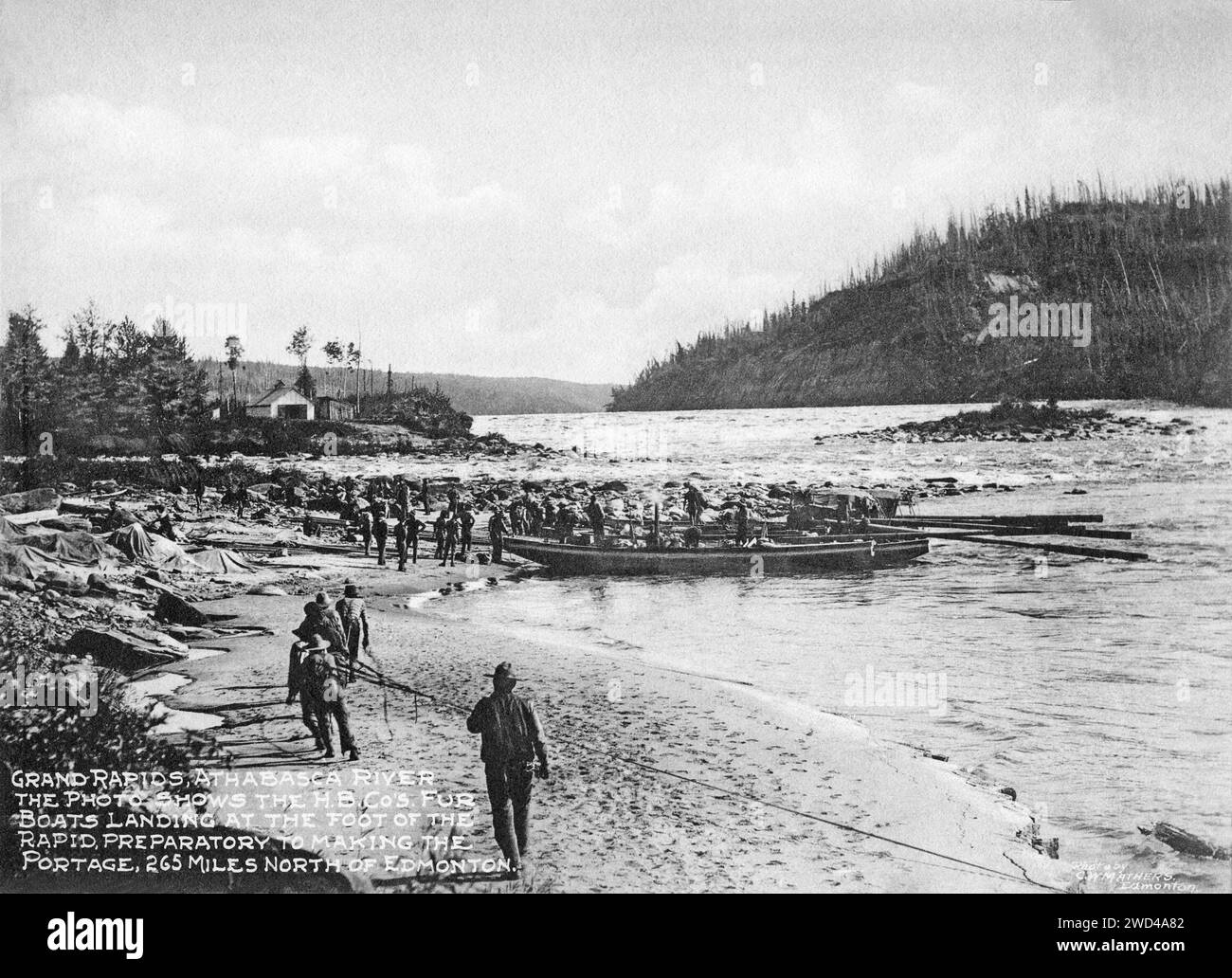 Una fotografia del 1901 di barche da pelliccia che sbarcano sul fiume Athabasca, Alberta, scattata da C W Mathers in una spedizione nell'estremo nord del Canada e pubblicata nel suo libro «l'estremo nord». Mathers didascalò questa foto: Grand Rapids, Athabasca River. La foto mostra le barche da pelliccia della H.B.Co. Che atterrano ai piedi della rapida, preparatoria alla realizzazione del portage, 265 miglia a nord di Edmonton. Foto Stock
