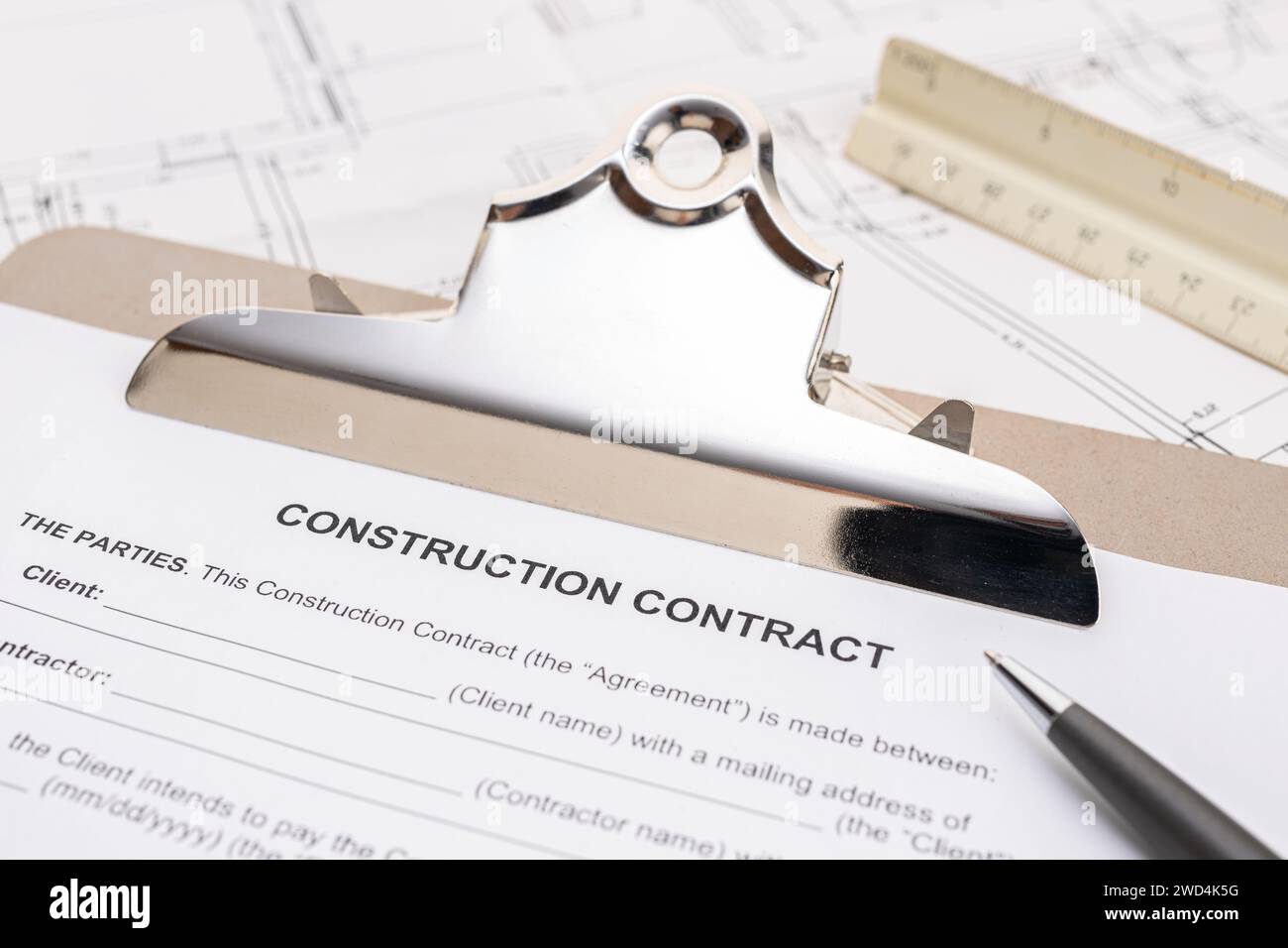 Documento del contratto di costruzione e penna sul tavolo. Immobili e pianificazione della costruzione di una casa o di un progetto di casa Foto Stock
