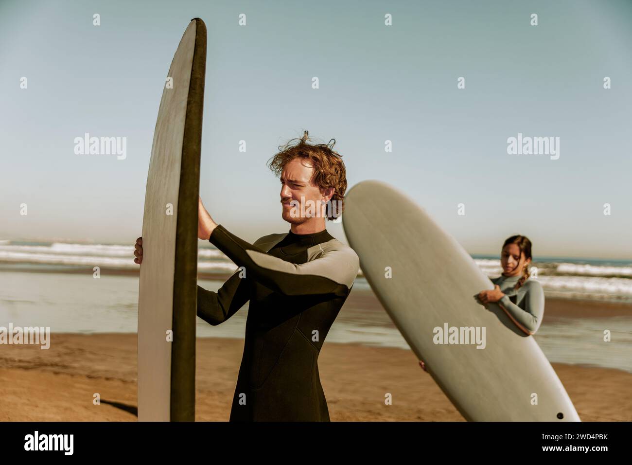 Fai surf in muta con tavole da surf e preparati a cavalcare le onde Foto Stock