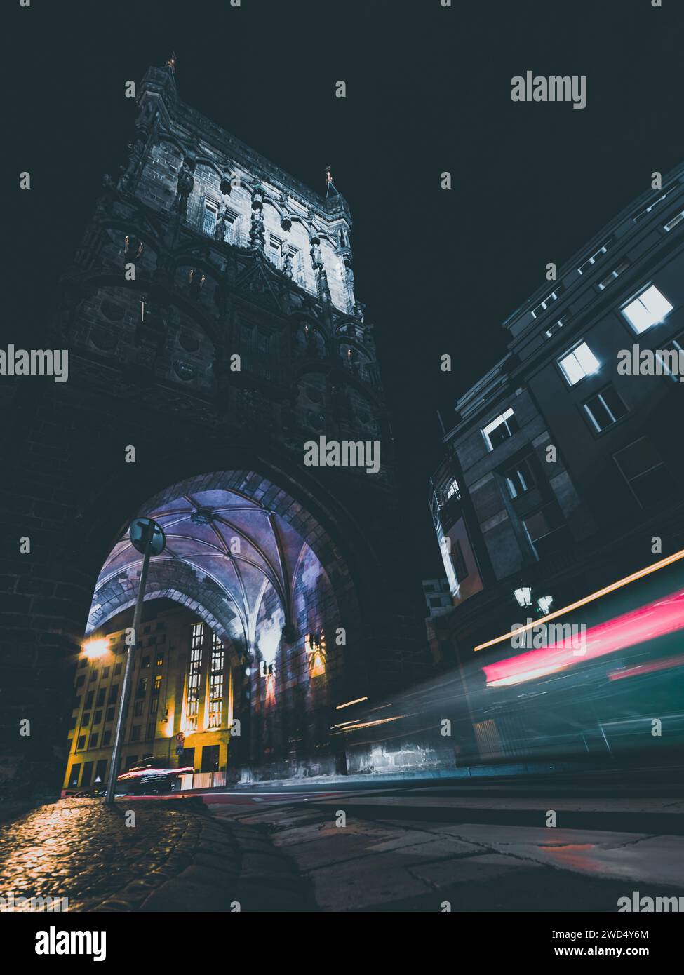 vecchia torre in città di notte con auto di passaggio Foto Stock