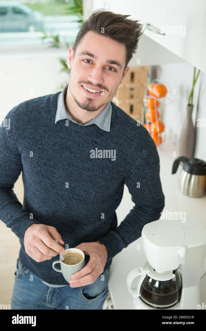 l'uomo a casa stava accanto alla sua macchina per il caffè Foto Stock