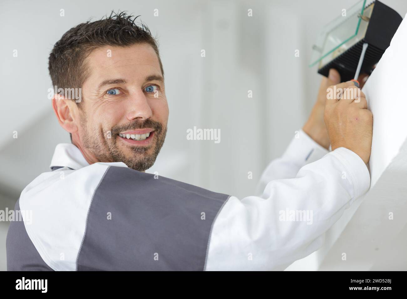tecnico delle luci che posa e sorride Foto Stock