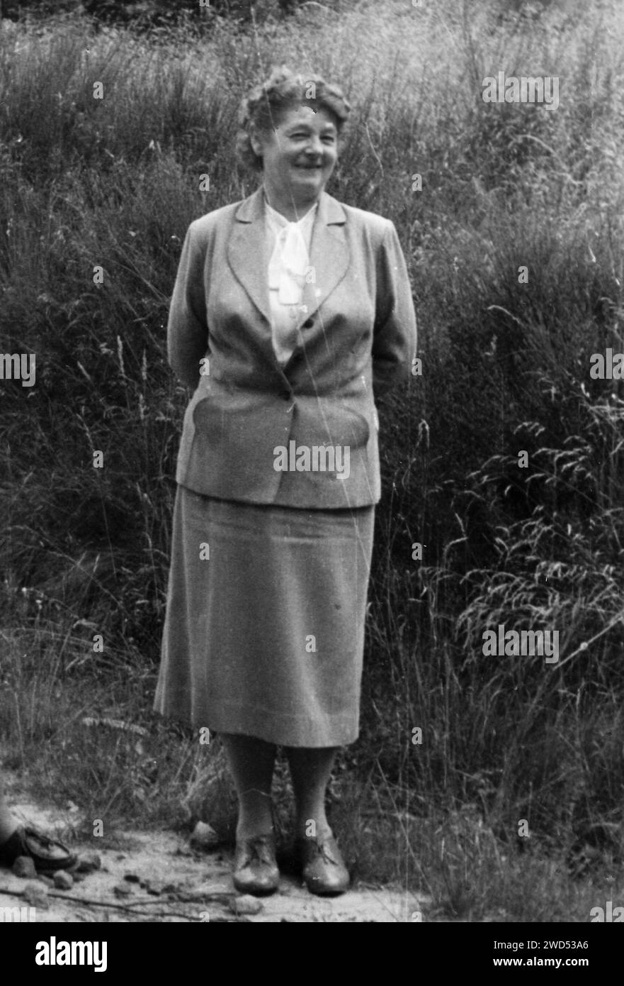 Un'antica foto con mostra una donna di mezza età in costume da lavoro che posa sullo sfondo di un pendio ricoperto di erba. Landau in der Pfalz, Foto Stock