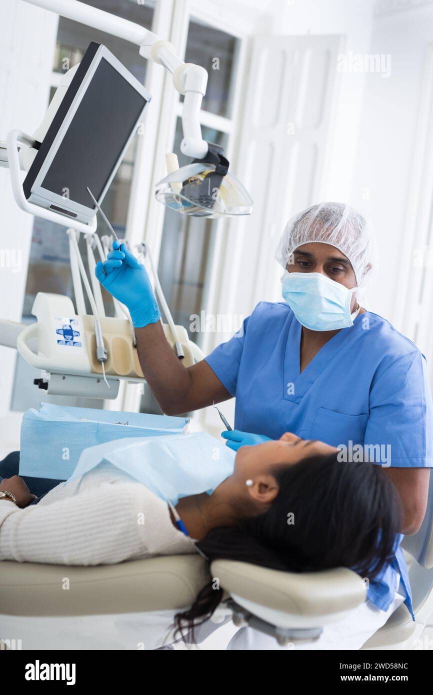 Dentista che mostra raggi X al paziente in clinica medica Foto Stock