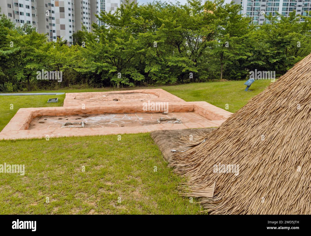 Impressioni concrete di antiche strutture dietro la capanna di paglia nel sito archeologico preistorico, Corea del Sud, Corea del Sud Foto Stock