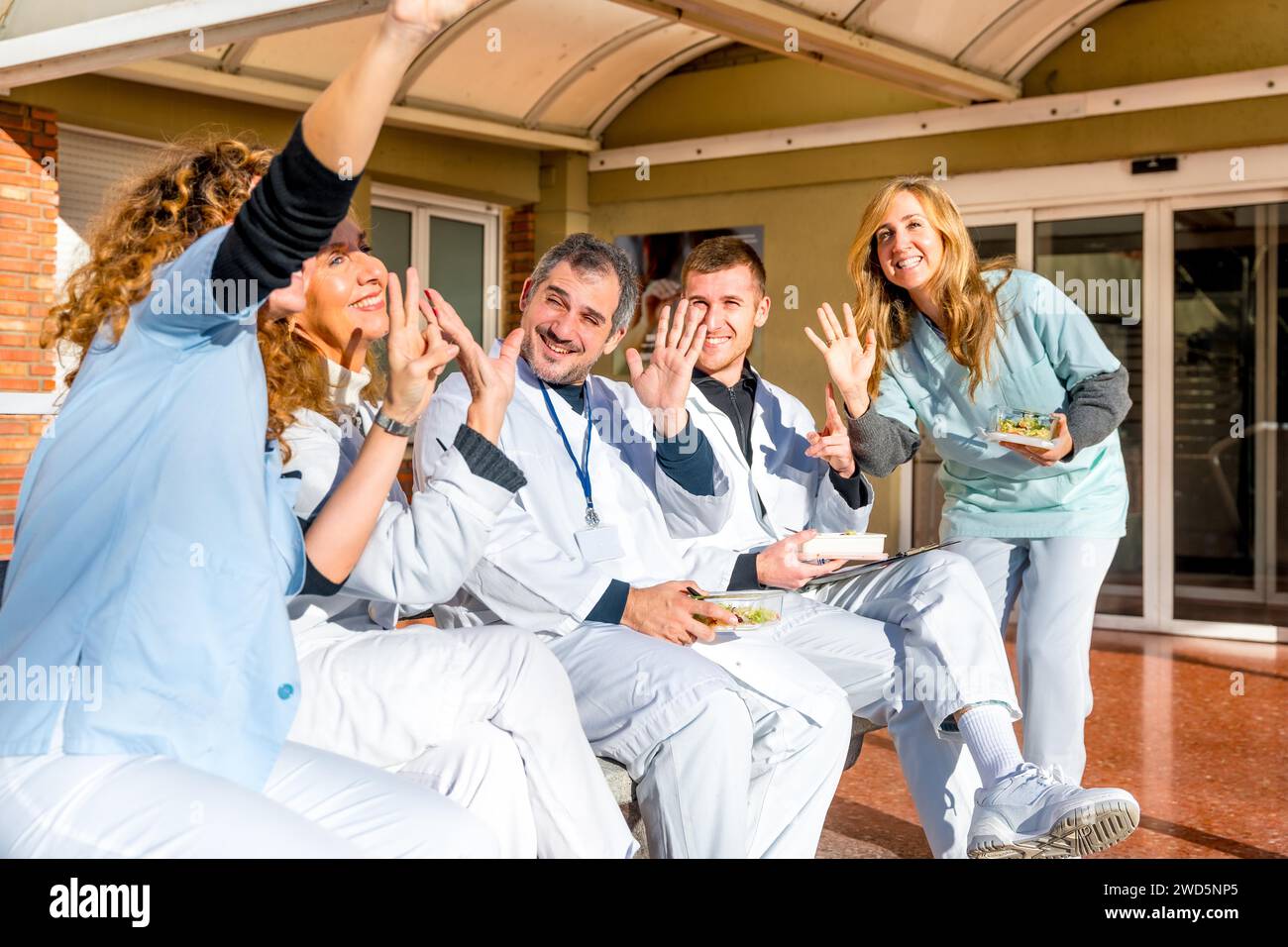 Un felice gruppo di medici e infermieri che fanno un selfie all'aperto durante una pausa pranzo al sole Foto Stock