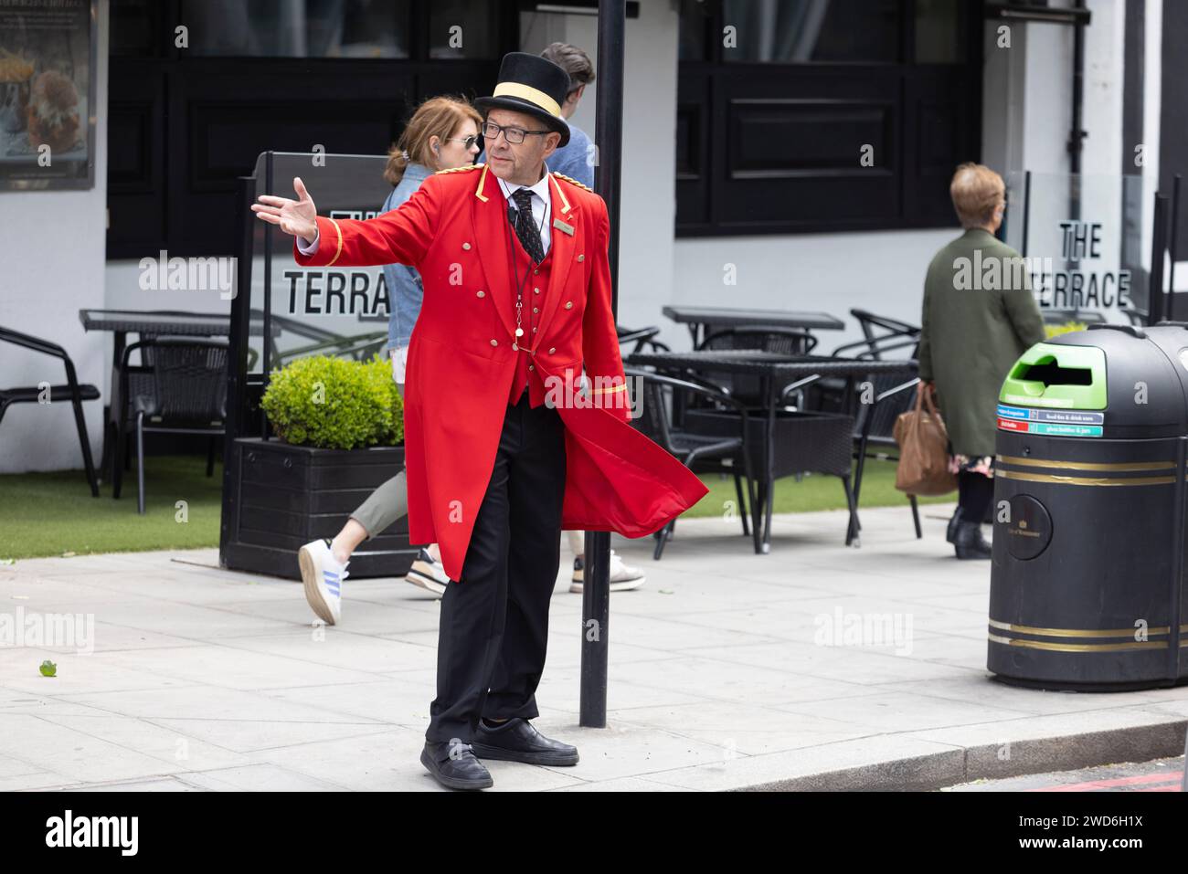 Un concierge vestito in elegante uniforme rossa tradizionale all'esterno del Rubens Hotel a Victoria, nel centro di Londra Foto Stock