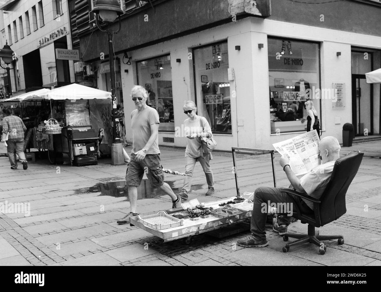Un venditore di frutta serbo che legge il giornale nel centro di Belgrado, Serbia. Foto Stock