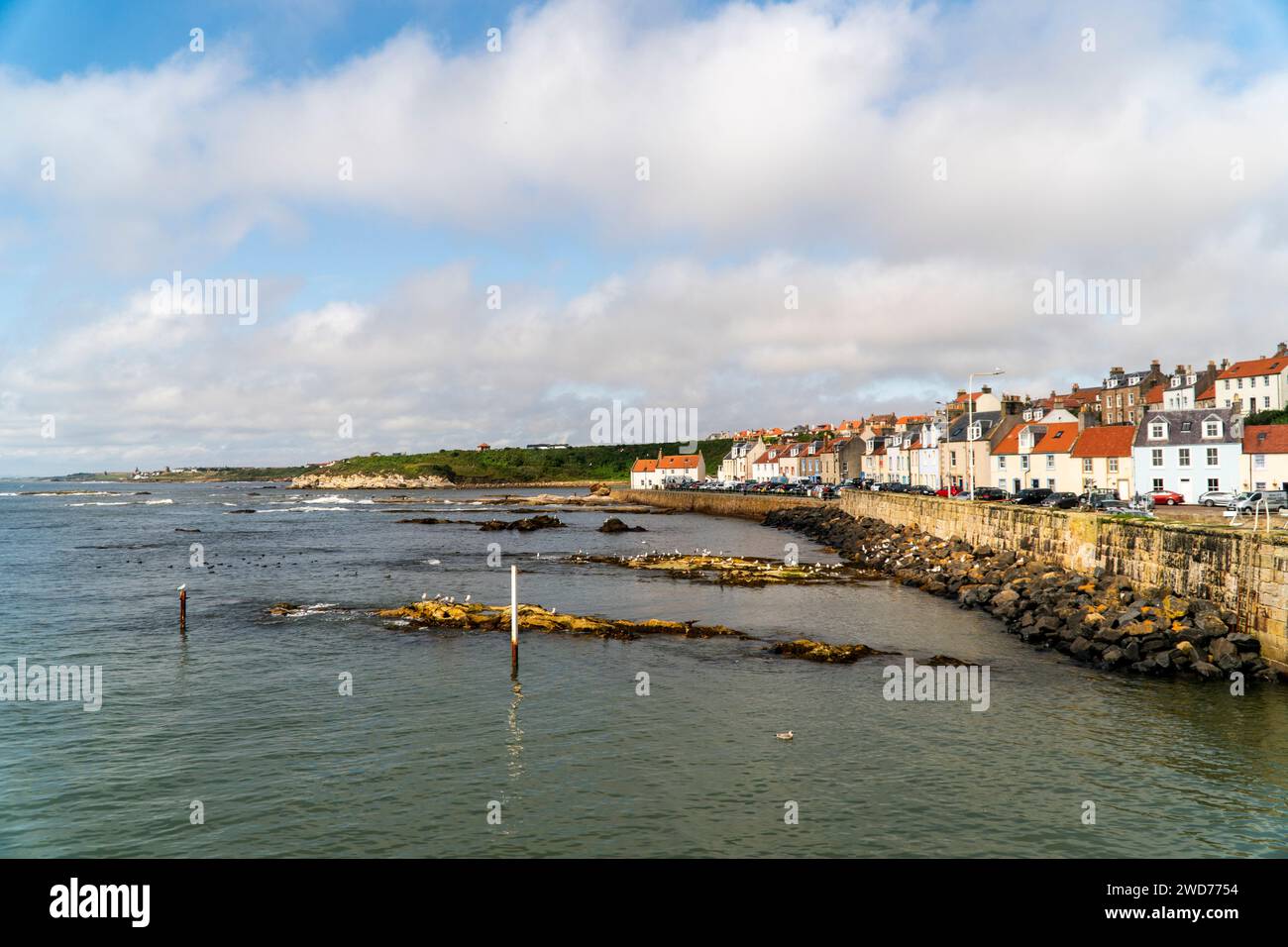 Una pittoresca scena costiera con incantevoli residenze sul mare che costeggiano le mura del mare Foto Stock