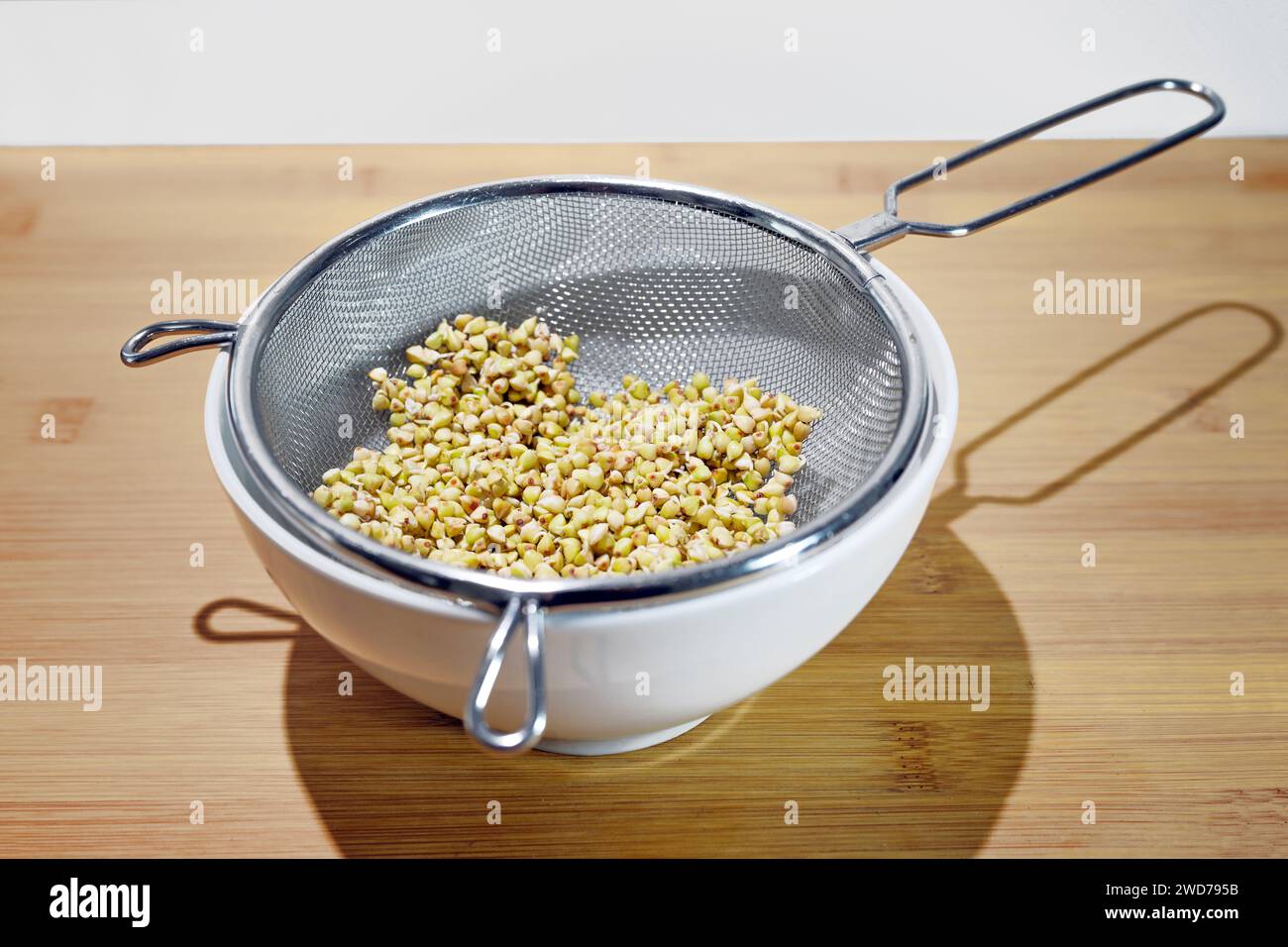 Germinare semi di grano saraceno in un setaccio da cucina fine su una ciotola, gli antiossidanti aumentano durante la germinazione, germogli sono sani, ricchi di vitamine, fibe Foto Stock
