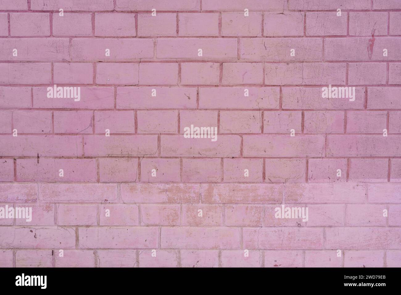 Un primo piano di un muro in mattoni rosa testurizzato Foto Stock