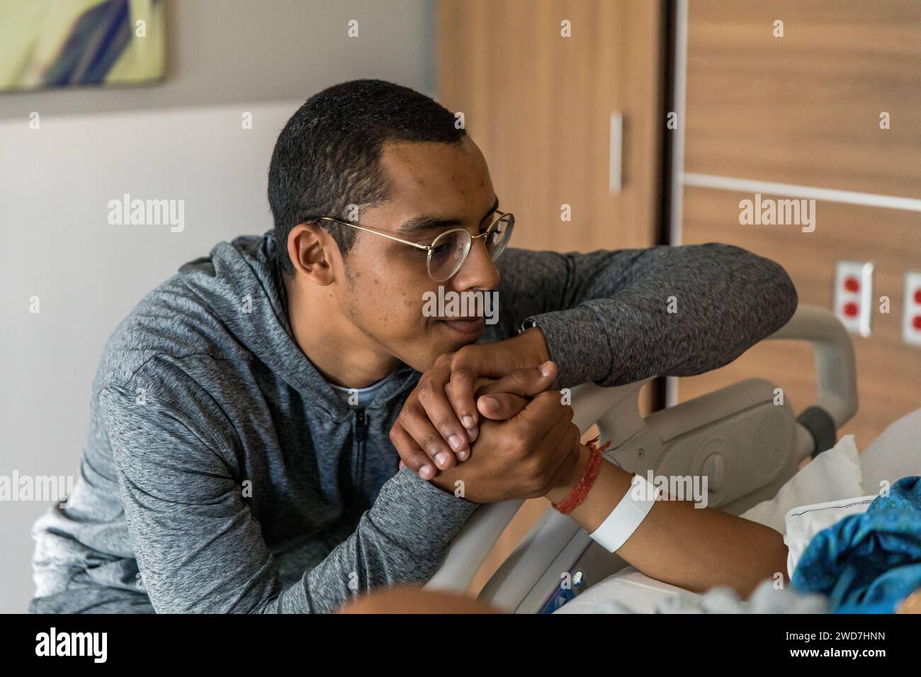 Papà afroamericano tiene la mano della moglie durante il travaglio Foto Stock