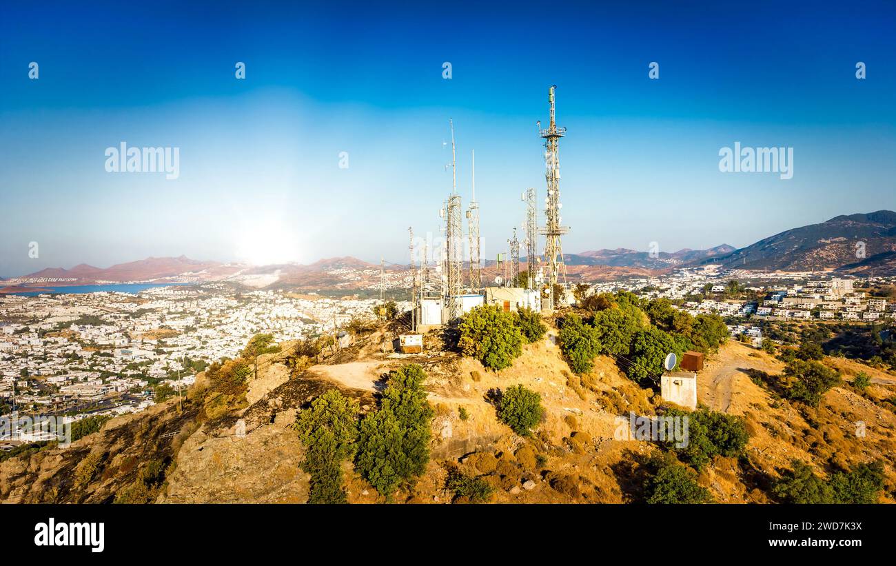 Torre di telecomunicazione in montagna con antenna di rete cellulare 4G 5G sullo sfondo della città. Tecnologia wireless per antenne TV con montante per telecomunicazioni Foto Stock