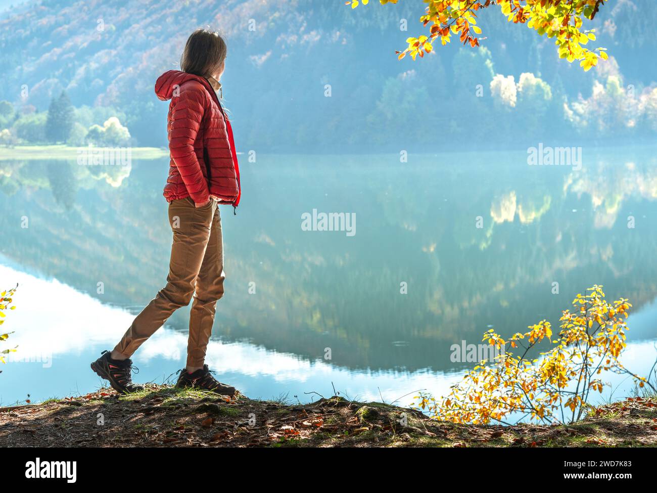 Donna irriconoscibile che cammina vicino al lago Turquoise in montagna Foto Stock