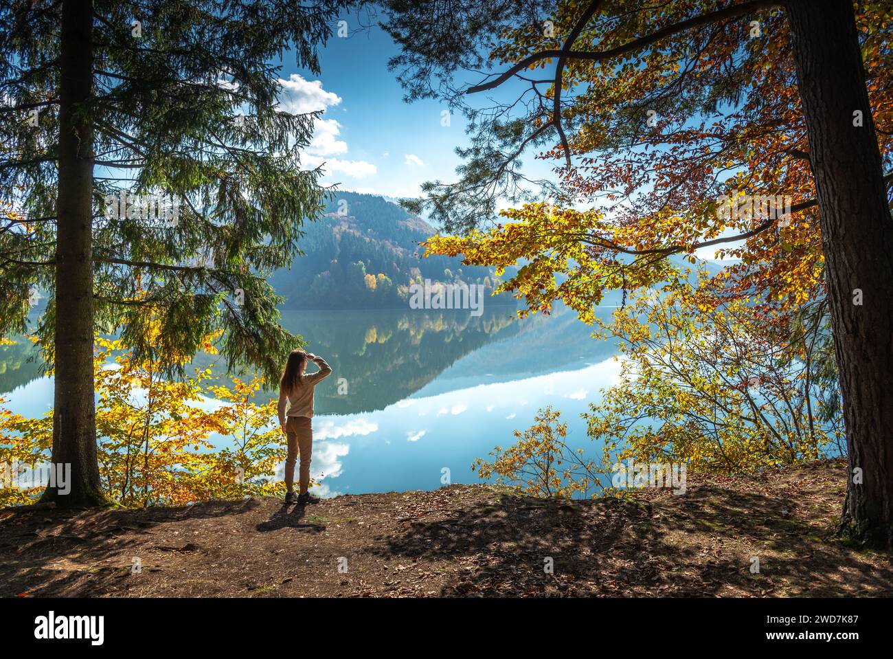 Irriconoscibile escursionista nei boschi con vista panoramica del lago Turchese Foto Stock