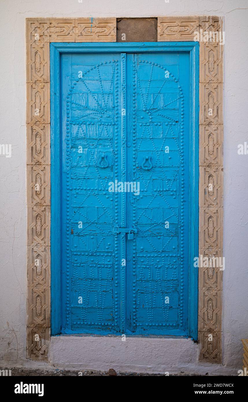 Un'antica porta blu decorata con simboli berberi nel cuore dell'antica medina a Kairouan, in Tunisia. Kairouan è la quarta città più Santa dell'Islam Foto Stock