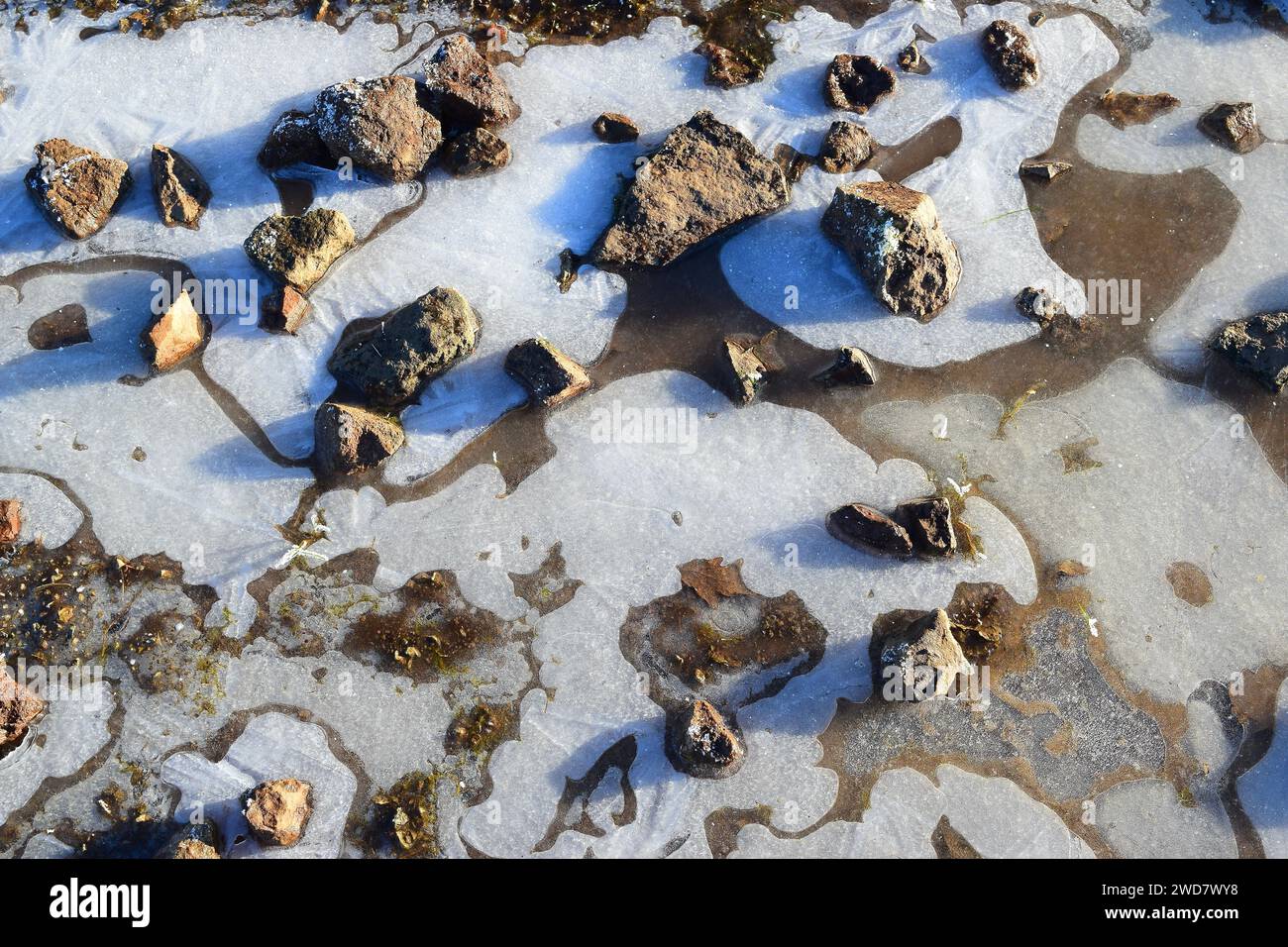 Terreno invernale con sfondo di ghiaccio, terreno coperto di ghiaccio ghiacciato e rocce Foto Stock