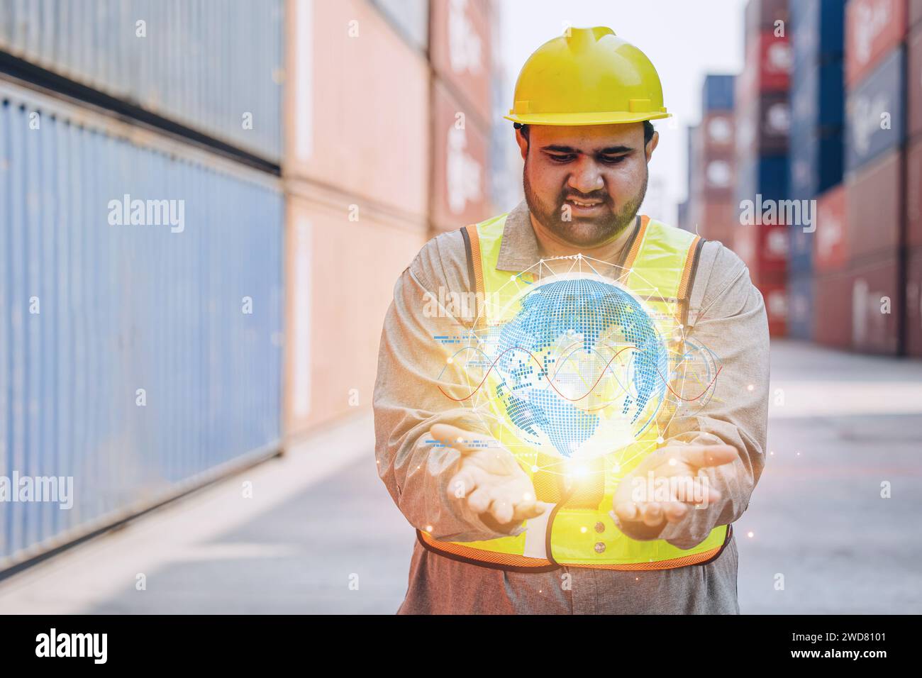 Ingegnere indiano dipendente maschile che cerca un concetto di business globale digitale a portata di mano per una facile gestione dei container, trasporto e spedizione in tutto il mondo Foto Stock