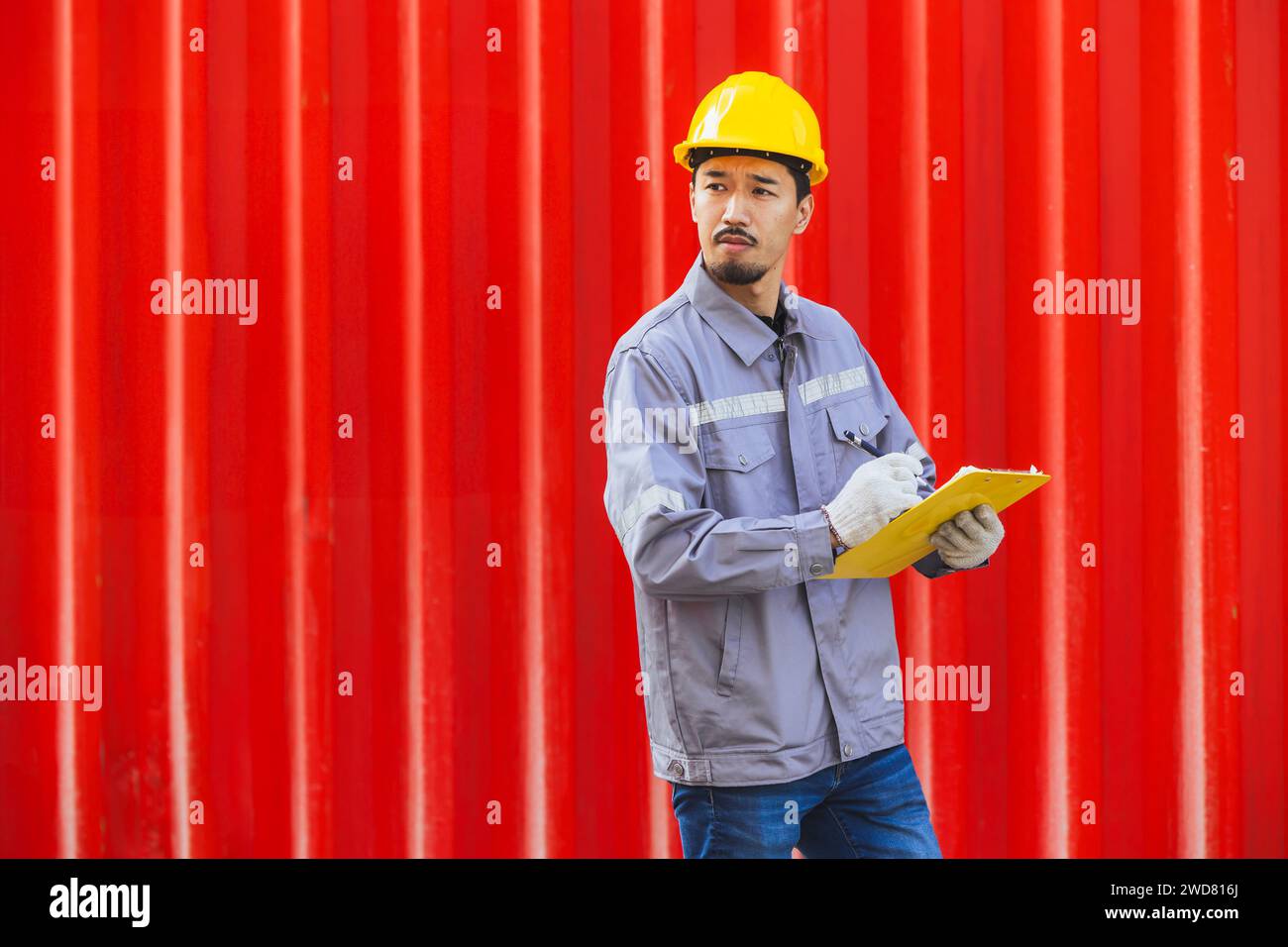 Lavoratore intelligente maschio giapponese che lavora nel carico del porto container. Personale doganale del settore logistico delle spedizioni in Giappone. Foto Stock