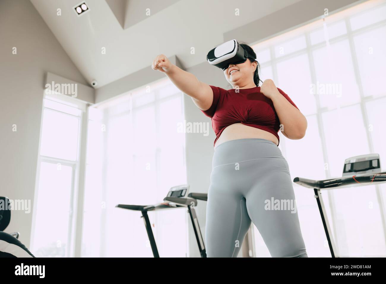Le donne grasse con visore VR giocano a un gioco sportivo di realtà visiva per l'esercizio fisico. persone che utilizzano la tecnologia moderna per il concetto di assistenza sanitaria. Foto Stock