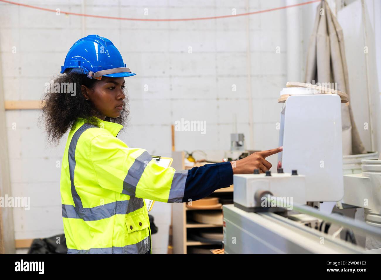 Le lavoratrici nere africane lavorano con l'industria della fabbrica di mobili della taglierina del legno con tuta di sicurezza Foto Stock