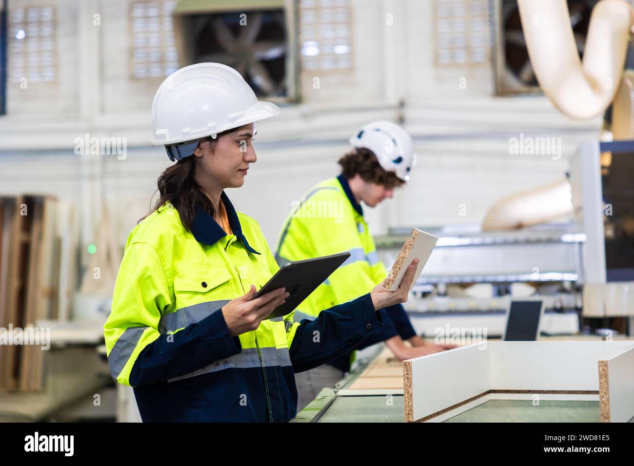 il personale del team ingegnere che lavora nel controllo della fabbrica di mobili in legno aziona la taglierina del legno Foto Stock