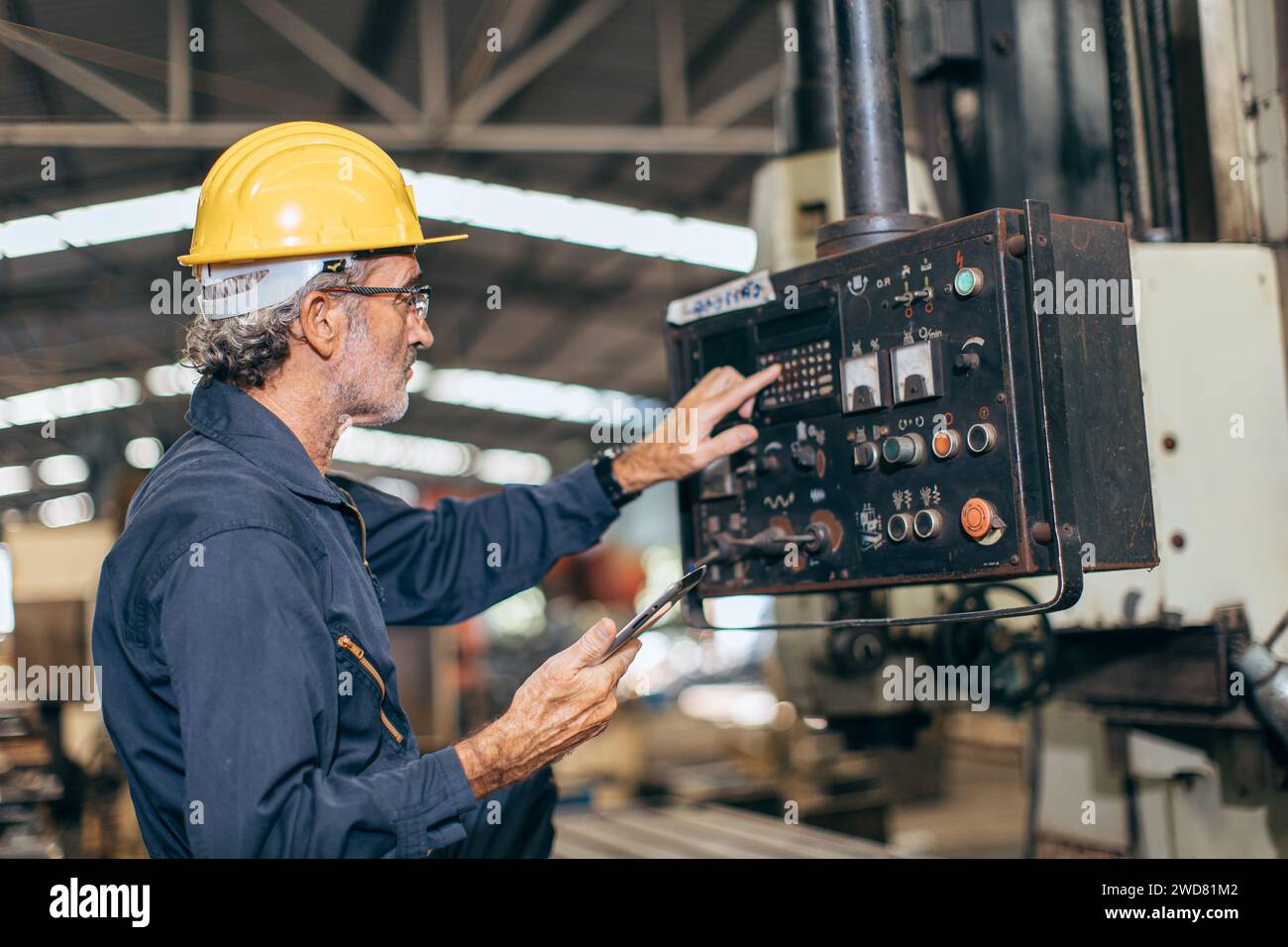 Il controllo del lavoro di un ingegnere professionista senior esegue il programma di fresatura CNC in una fabbrica dell'industria pesante Foto Stock