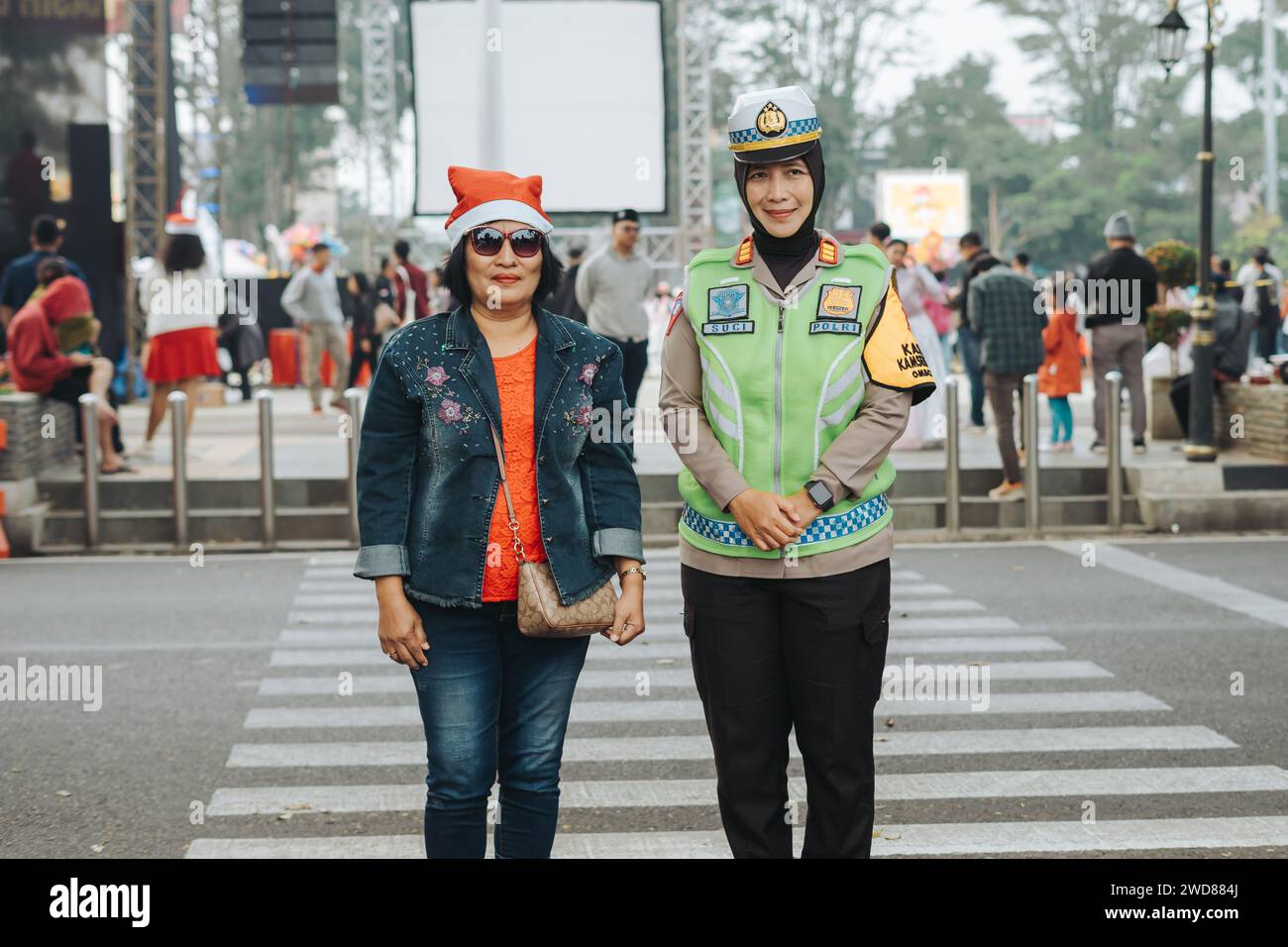 Donna della polizia (Polwan) che stringe la mano con cristiani o cattolici durante le celebrazioni natalizie a Salatiga, Indonesia - 25 dicembre 2023. Foto Stock