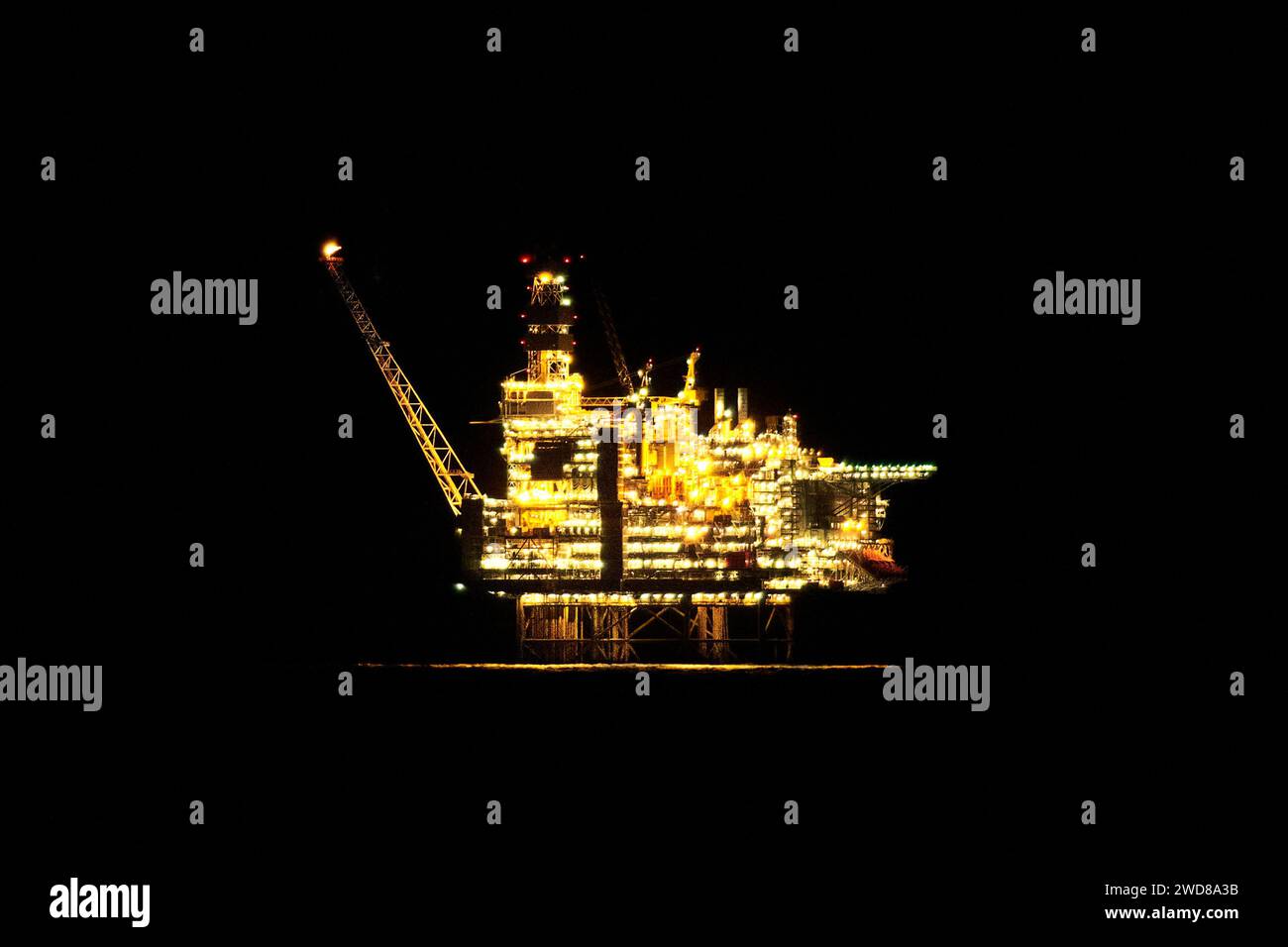Vista ravvicinata del carro di perforazione illuminato di notte nell'oceano. Foto Stock