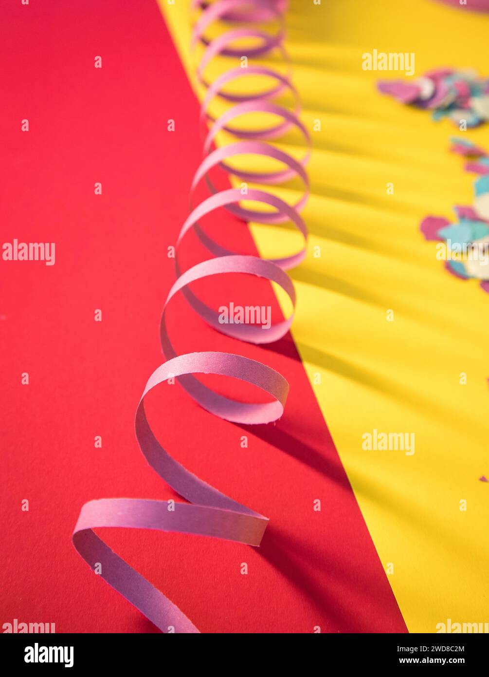 Immagine simbolica che allude al Carnevale utilizzando rastrellieri e coriandoli che trasmettono molti colori tipici della stagione festiva. Copia spazio. Foto Stock
