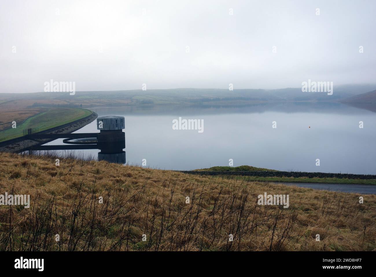 Il muro della diga e la Stone Outlet Tower nelle acque ferme del lago artificiale Grimwith nel parco nazionale Yorkshire Dales, Inghilterra, Regno Unito. Foto Stock