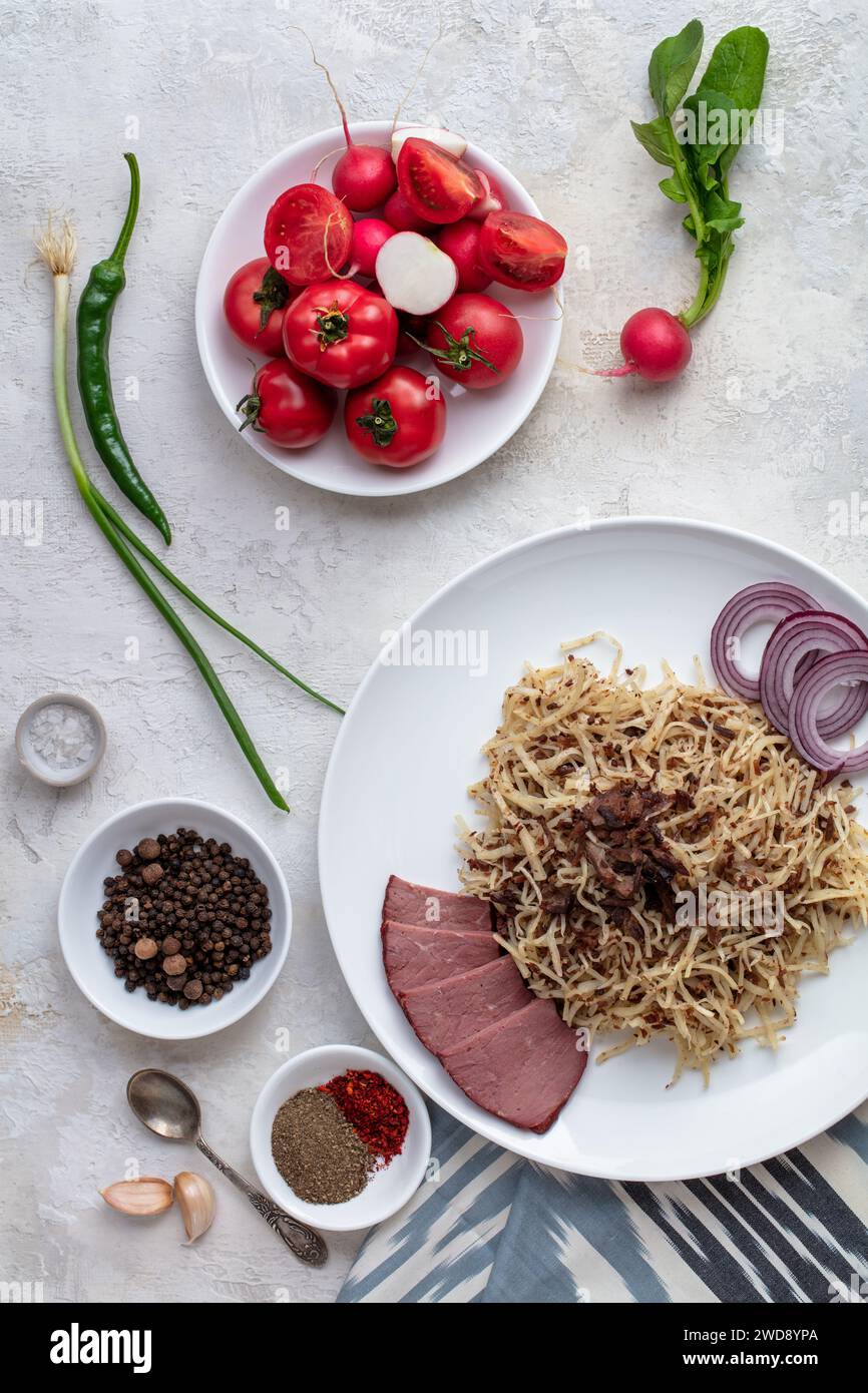 Cibo uzbeko Naryn con impasto tritato e carne. Servita con verdure e spezie. Vista verticale appiattita Foto Stock