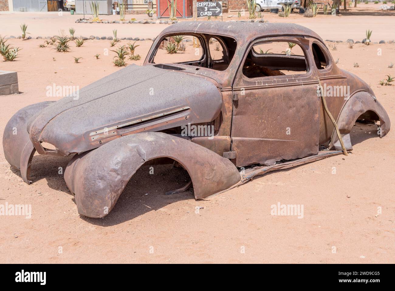 Relitto della carrozzeria di un'auto d'epoca anni '40 consumato dalla ruggine in mostra presso la stazione di rifornimento nel deserto di Naukluft, sparato in tarda primavera a Betta, Namibia, A. Foto Stock