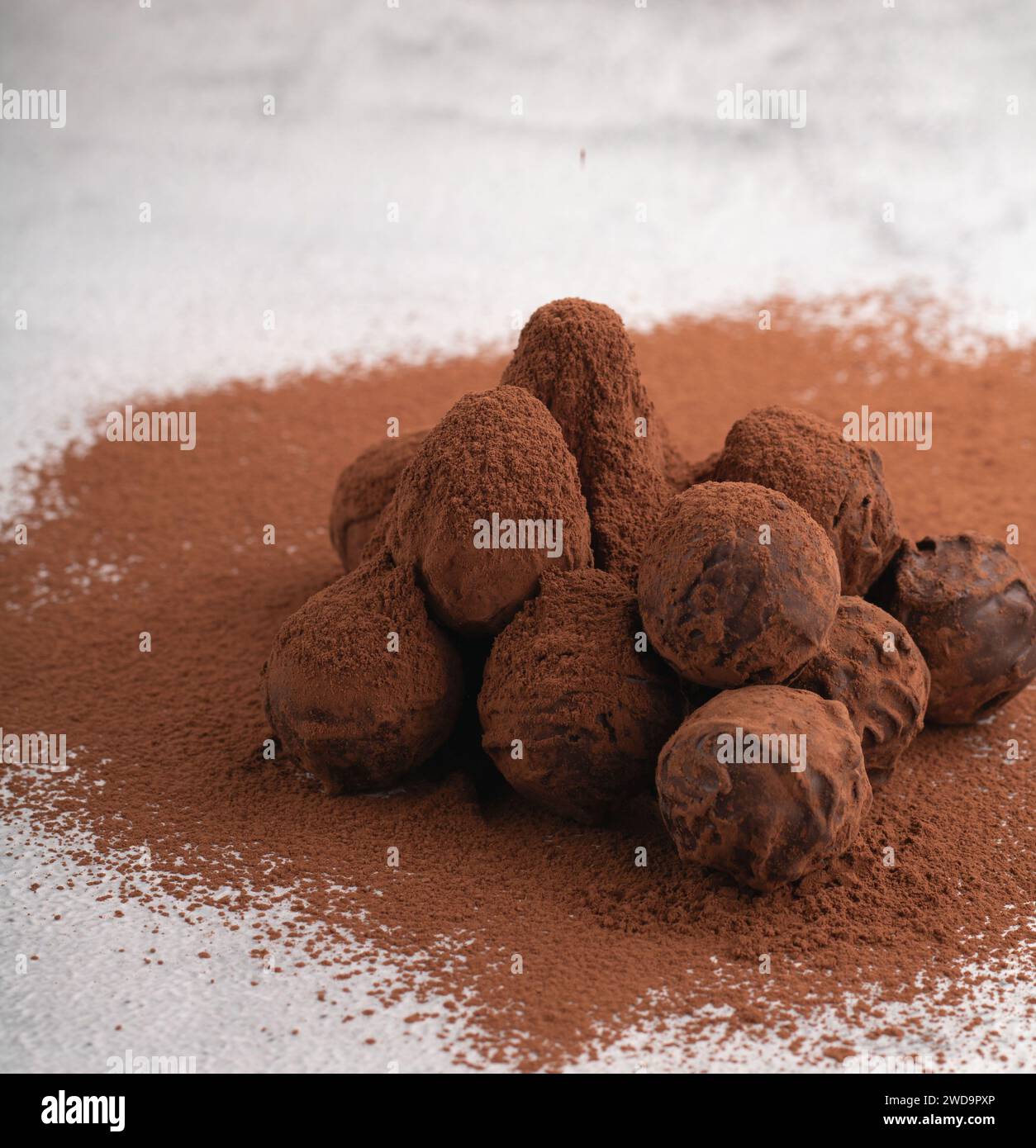 foto di un delizioso tartufo al cioccolato spolverato con cacao in polvere, creando un dolce e allettante dessert. Questa deliziosa caramella si fonde perfettamente Foto Stock