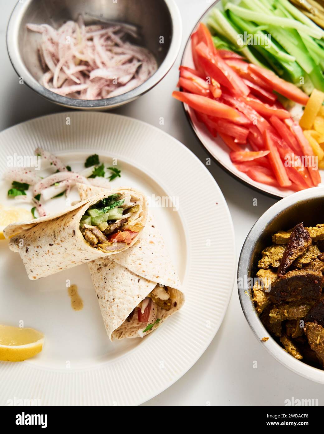 Shawarma in stile libanese di manzo e agnello con cipolle, verdure e cetrioli e pomodori. tutto condito con tahini e salsa all'aglio e. Foto Stock