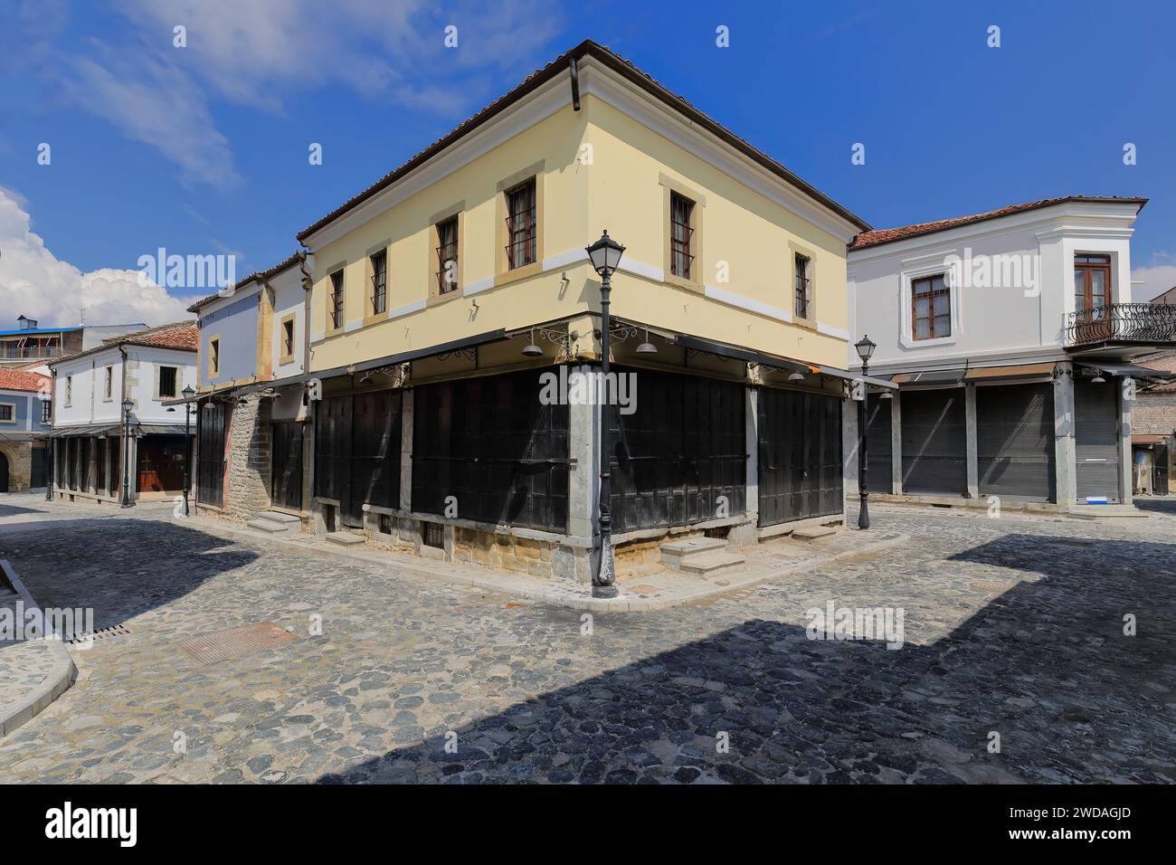 256 Casa ad angolo in stile ottomano di colore giallo, realizzata in mattoni lavorati su ciottoli di Rugica Jovan Spiro Kosturi, area del vecchio Bazaar. Korca-Albania. Foto Stock