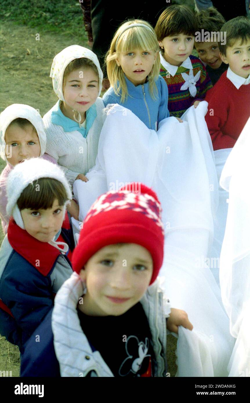 Contea di Vrancea, Romania, circa 1990. Gruppo di bambini che trasportano il treno di un abito da sposa. Foto Stock