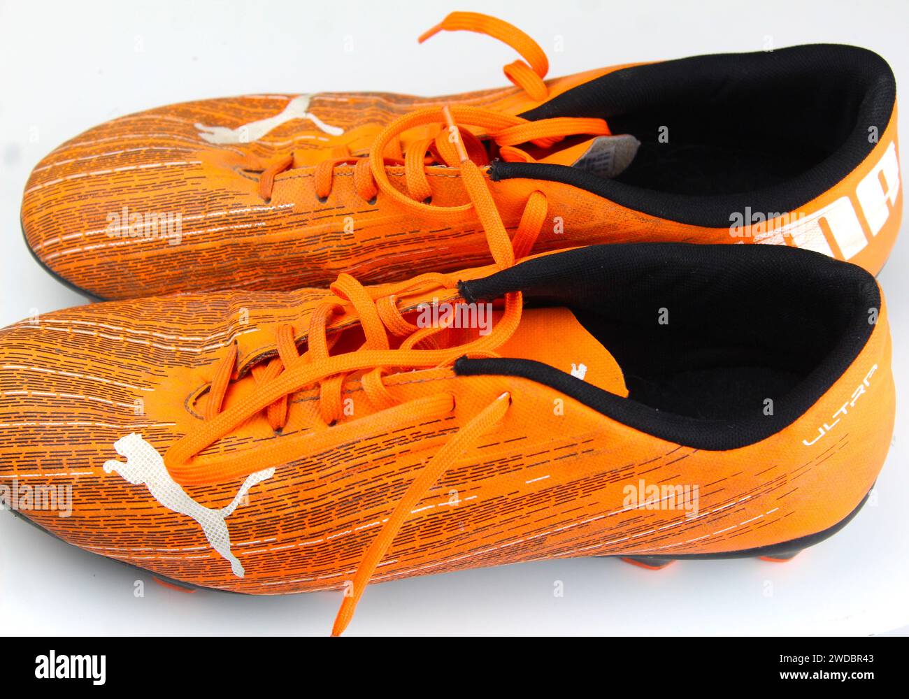 Dublino, Irlanda - 13 febbraio 2024: Una foto di scarpe da calcio arancioni PUMA Kids ultra 4,1 su una superficie bianca. Foto Stock
